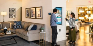 Consumidores visualizando os produtos em totem tecnológico