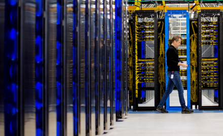 Image of a worker walking through a datacenter.