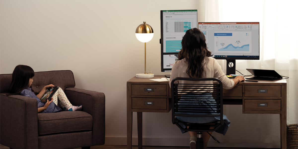 An image of a mother and her daughter are working and learning remotely in their living room.