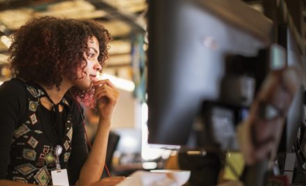 Adult female IT professional working at her computer station.