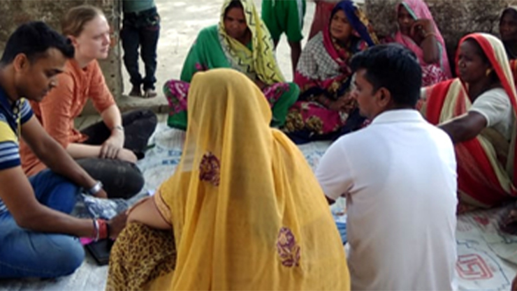 Men and women sitting on the floor in a circle