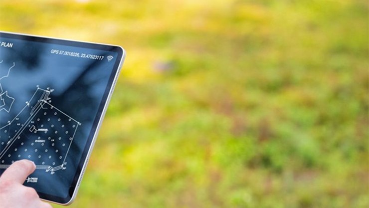 side view of a touch screen with some blurry grass in the background