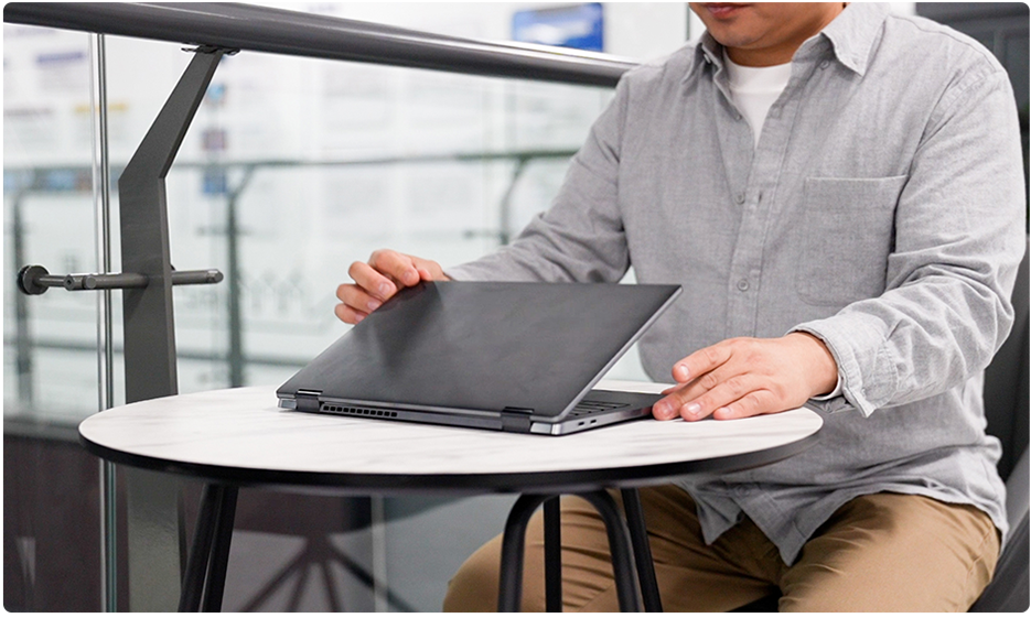 这里显示办公室里，一个穿着工作服的人正在打开电脑