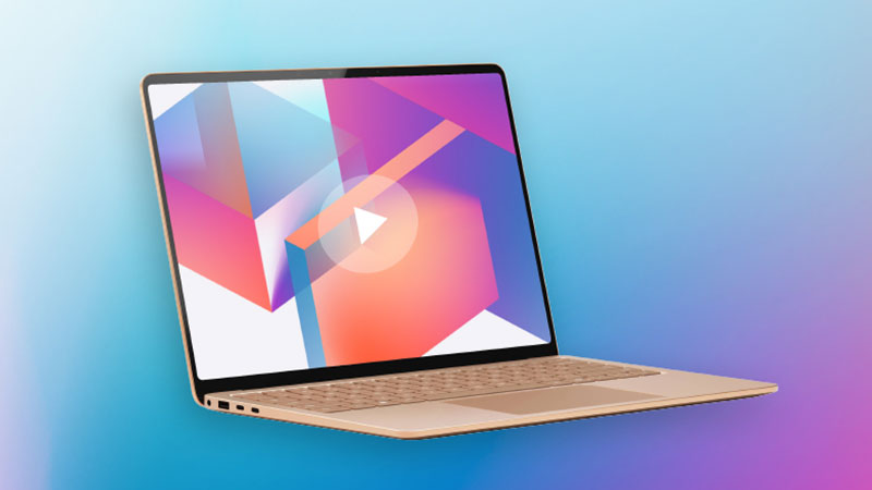 一部金色的筆記型電腦呈角度放置在藍色和紫色的漸變背景上。螢幕顯示著一幅抽象的多彩幾何形狀圖像，並覆蓋著一個白色的播放按鈕。