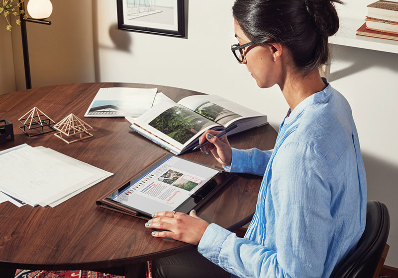 一名女性坐在桌前用觸控筆操作平板電腦的照片圖示