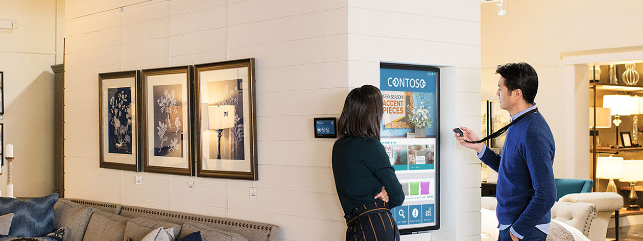 店員使用數位互動裝置向一旁的客戶介紹店中商品的主視覺照片圖示